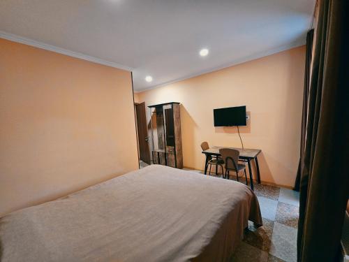 Ch'argaliTourist Complex Khomi的酒店客房配有一张床铺和一张桌子。