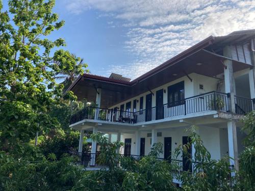 波隆纳鲁沃Hotel Siyathma polonnaruwa的带阳台和树木的白色房屋