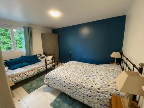 勒库德雷·蒙特考克斯Maison dans parc privé, sports et loisirs proche golf du Coudray Montceaux的一间卧室设有一张床和蓝色的墙壁