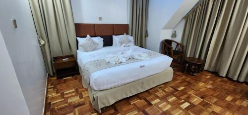 ShameneiAngani Resorts & Spa Limited的一间卧室配有带白色床单和枕头的床。
