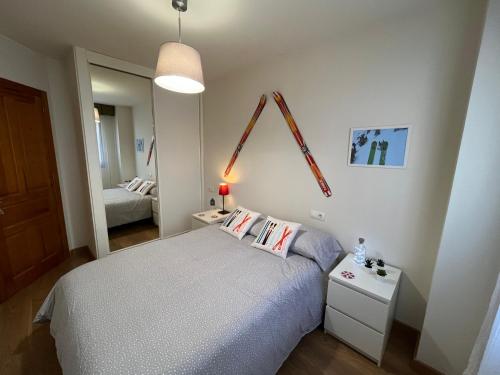 圣伊西德罗Precioso apartamento en San Isidro , ski , snow的一间小卧室,配有一张床和镜子