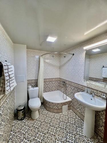 布哈拉阿拉奔酒店的浴室配有卫生间、盥洗盆和浴缸。