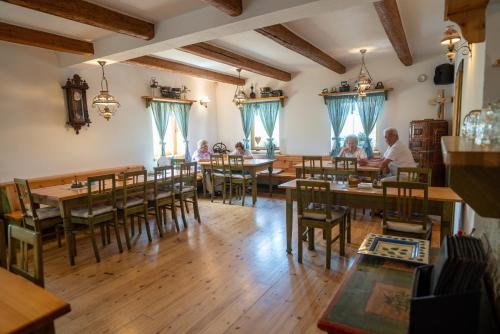 弗兰季谢克矿泉镇Pension Kamenný Dvůr的餐厅设有木桌,客人坐在桌子旁