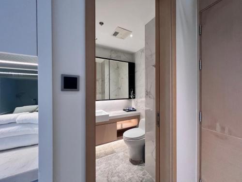 深圳凯森希悦酒店公寓(深圳国际会展中心店)的一间带卫生间、水槽和床的浴室