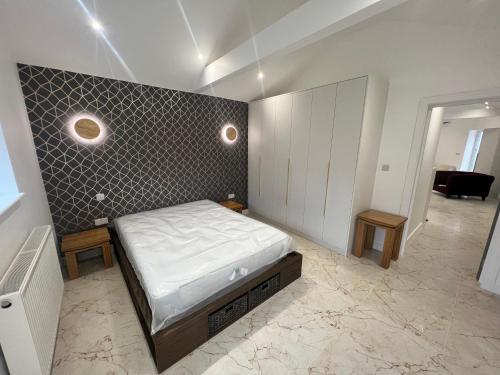 格林福德Cozy Luxury Private Cottage的一间卧室设有一张床和一面墙