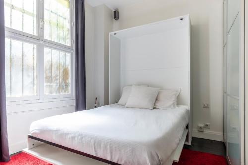 巴黎Studio sur les quais de Seine的卧室配有白色的床和窗户。