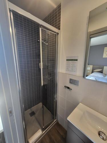 昂代贝尔维酒店的带淋浴、盥洗盆和镜子的浴室