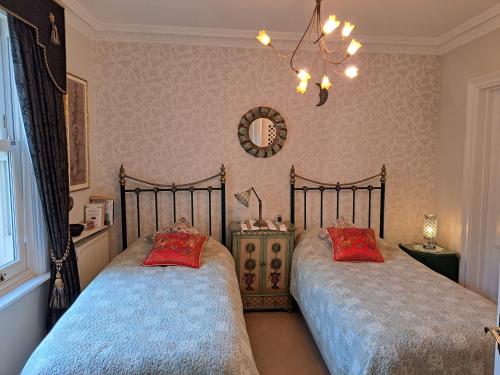 塔维斯托克Lloyds Penthouse的一间卧室配有两张床和镜子