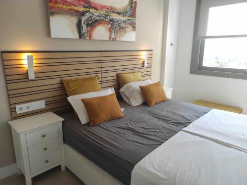 卡莱塔德贝莱斯Appartement Baviera Hills - Torre del Mar - Costa del Sol的一间卧室配有一张大床和木制床头板