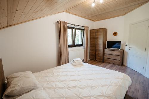 Băile BorşaGreen Garden的卧室配有一张白色大床和电视。