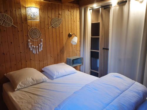 卡布尔Chalet à Cabourg的一间卧室设有一张床和木墙