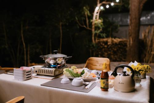 Ban Huai KhaiArabica Lodge (อาราบิก้า ลอดจ์)的桌子上放着一壶和一盘食物