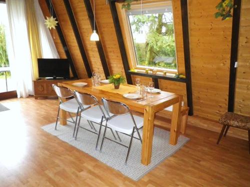 布兰肯海姆Ferienhaus-Freilingen的一间带木桌和椅子的用餐室