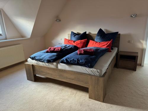 德累斯顿205 qm "Traumtor" mit Sauna, Whirlpool, Kamin und 3 Terrassen mit Blick in die Böhmisch Sächsische Schweiz的一张带蓝色和红色枕头的床