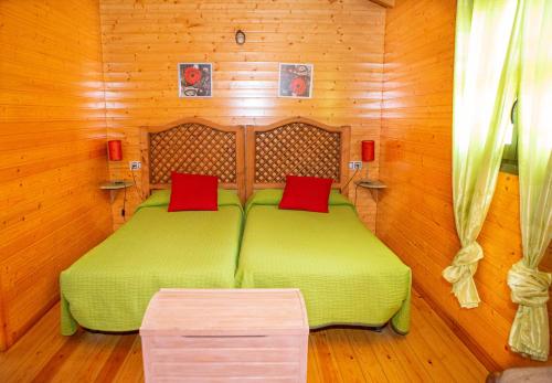 Rebollar厄尔林孔德尔赫尔特乡村公寓酒店的一间卧室配有带红色枕头的绿色床