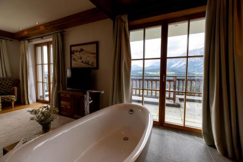 斯拉德明Chalet Bergmueller的带浴缸的大浴室和阳台