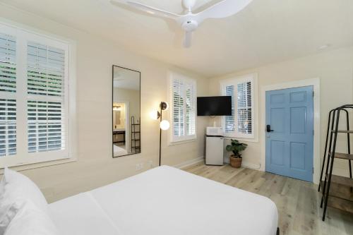 基韦斯特Tranquillity Guest House的白色卧室设有白色的床和蓝色门
