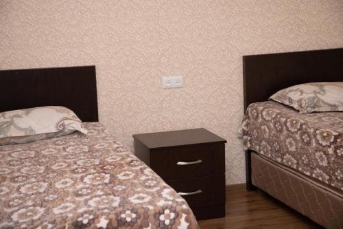 塞凡Sevan Hotel的一间卧室设有两张床,一个床头柜和两张床