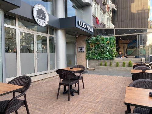伊斯坦布尔Olen Uskudar Hotel的大楼前设有桌椅的餐厅