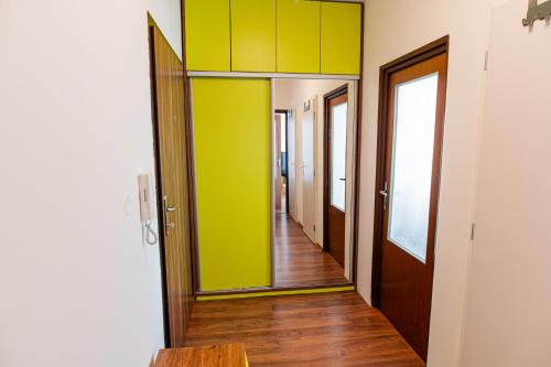 布拉迪斯拉发Room 1 km from center的走廊设有绿色和黄色的墙壁,铺有木地板