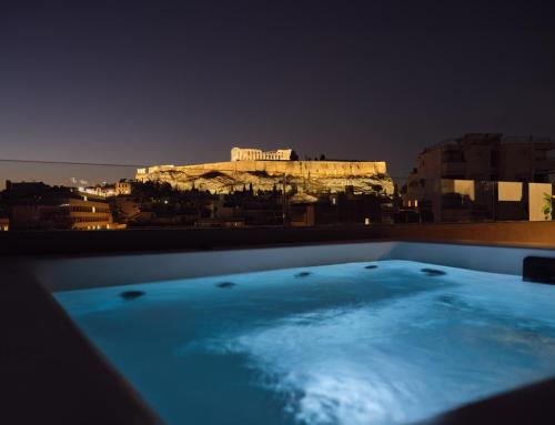 雅典Urban Stripes Athens的浴缸,晚上可欣赏到雅典卫城的景色