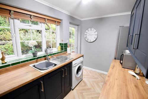 马尔文维尔Charming Malvern Cottage with Outstanding Views的厨房配有水槽和洗衣机