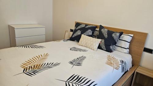 巴约讷Apartamento Sabaris Playa的一张带叶子的黑白床