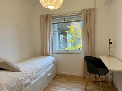 斯德哥尔摩Apartment with amazing view的一间卧室配有一张床、一张书桌和一个窗户。