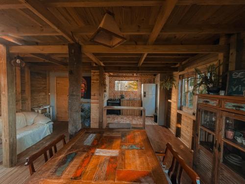普腊亚罗萨Pousada Vale da Magia的小屋内带木桌的用餐室