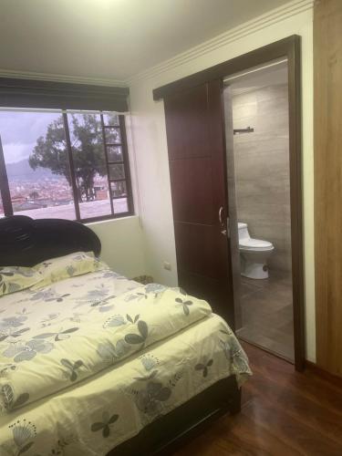 昆卡Evangelio Inn的一间卧室配有一张床,浴室设有卫生间