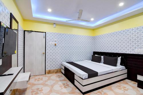 加尔各答Super OYO Anandalok Guest House的一间卧室配有一张床和一台电视。
