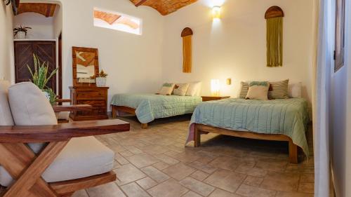 洛德马科斯QUINTA BERNAL的客厅配有两张床和椅子