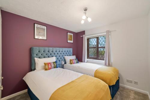 StoneBeautiful 5 bedroom house in Stone, Aylesbury, Free parking的紫黄色间内的两张床