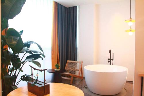 成都熙蜀酒店的带浴缸、桌子和植物的浴室