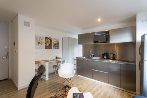 波哥大Loft nuevo, moderno, central的厨房配有不锈钢橱柜和白色椅子