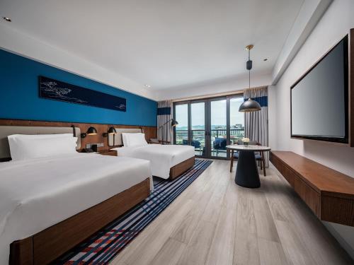 三亚三亚海棠湾茅台度假村茅台珍品酒店的酒店客房设有两张床和一台平面电视。