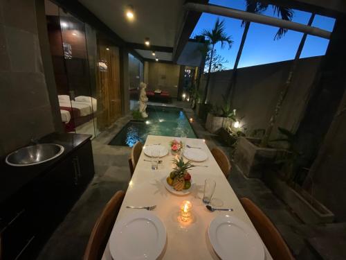 金巴兰巴厘岛金象精品别墅的一间带桌子和游泳池的用餐室