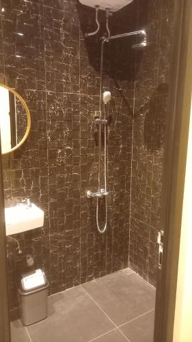 乌鲁瓦图Rumah WJ rooms and suites的带淋浴和卫生间的黑色瓷砖浴室