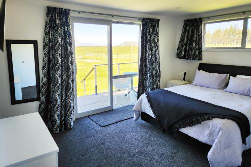 特威泽尔Glen View Escape的一间卧室设有一张床和一个滑动玻璃门