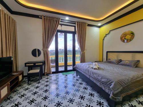 保禄Quê hương Villa (Indochine Villas Tam Chau)的一间卧室配有一张床、一台电视和一张书桌