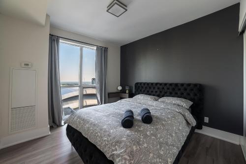 多伦多Designer condo w/ CN Tower view & parking的一间卧室配有一张带黑色墙壁和窗户的床。