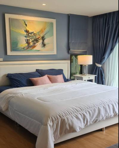 บ้านสวนภาคินรัตน์的一间卧室配有一张带蓝色墙壁的大床