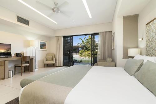 达尔文Mindil Beach Casino Resort的一间卧室配有一张大床、一张桌子和一台电脑