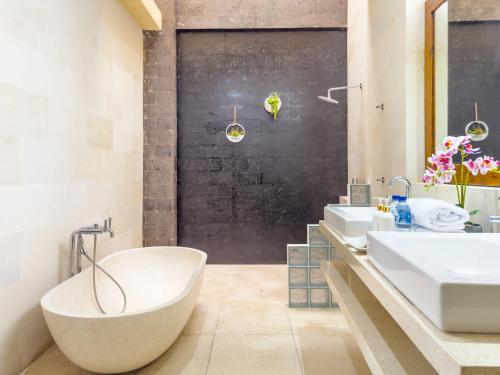 坎古Villa Echo Taman Bali的浴室配有2个盥洗盆和1个浴缸。