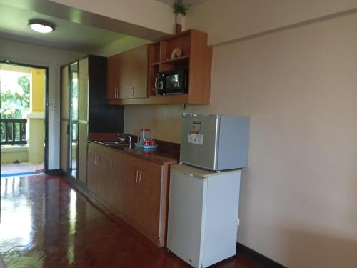 长滩岛Apo 201-Alta Vista De Boracay的厨房配有白色冰箱和木制橱柜。