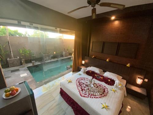 金巴兰巴厘岛金象精品别墅的一间卧室设有一张床和一个游泳池