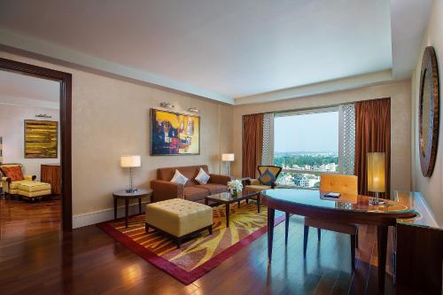 班加罗尔班加罗尔丽思卡尔顿酒店的客厅配有沙发和桌子