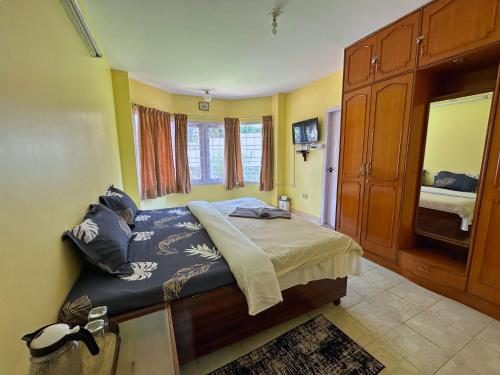 乌提Priyadeep BnB的卧室配有一张床铺,位于一个黄色墙壁的房间