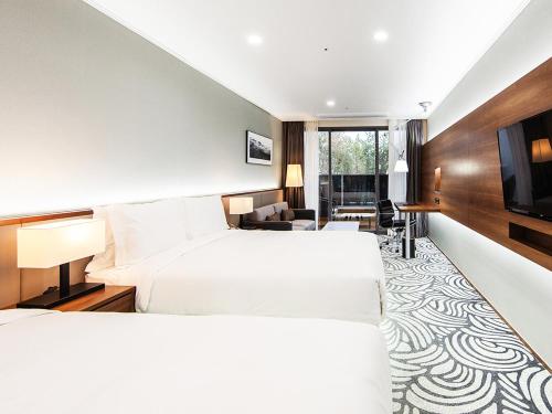 庆州Best Western Plus GyeongJu的酒店客房设有两张床和一台平面电视。