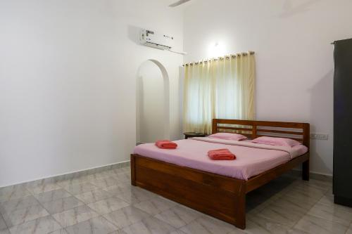 瓦加托Hill Top Nest的一间卧室配有带粉红色枕头的床。
